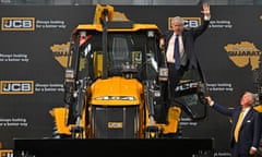 Boris Johnson waves from an excavator as JCB chairman Lord Bamford watches at the company’s factory in Vadodara, Gujarat.