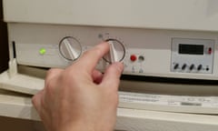 Someone adjusts a dial on the control panel of a gas boiler