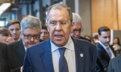 Sergei Lavrov walking along a corridor in a crowd of people