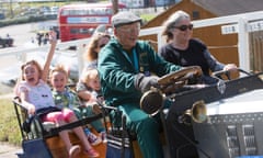 A family are taken for a drive in a vintage car at Brooklands Museum, near Weybridge, Surrey.