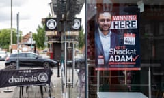 A campaign poster for Shockat Adam in a window