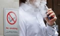 Man vaping beside no smoking sign