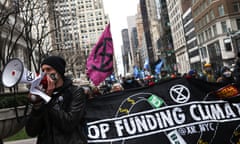 Demonstrators march in New York City on 2 April in solidarity with the #StopTheMoneyPipeline coalition.