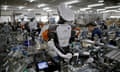 Humanoid robots work side by side with employees in the assembly line at a factory in Kazo, north of Tokyo, Japan.