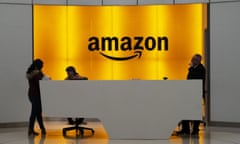 FILE - In this Feb. 14, 2019 file photo, people stand in the lobby for Amazon offices in New York. Amazon is providing a tool that will allow brands to remove listings from its site themselves that they consider to be for counterfeit goods. The online giant is also launching a product serialization service, which allows brands to put unique codes on their products during the manufacturing process. The codes are then scanned by Amazon to confirm authenticity once purchased. (AP Photo/Mark Lennihan, File)