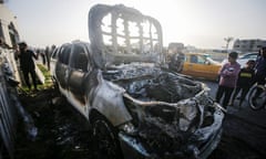 People near a destroyed car of the World Central Kitchen in early April after Israeli strikes on an aid convoy killed seven workers