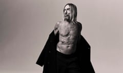 Iggy Pop naked to the waist, shrugging off a big coat