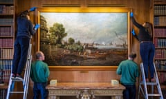 Conservators wearing blue gloves hang Constable’s painting Embarkation of George IV from Whitehall: The Opening of Waterloo Bridge after lengthy restoration works