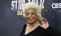 A portrait of Nichelle Nichols waving to the camera at a Star Trek event.