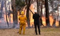 Local resisdent Attila Hegedus (right) and a fire fighter look on at a fire near a property in Raglan, Victoria, Australia, 23 February 2024.