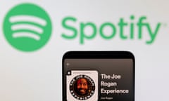 the joe rogan podcast on an iphone screen with the spotify logo behind