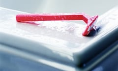 Pink razor on the rim of a bath