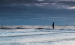 The incoming tide swirls around an Iron Man on Crosby beach, one of 100 statues modelled on and created by Antony Gormley.