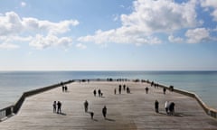Hastings residents walk on the town's newly reopened pier