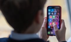 A schoolboy looks at an iPhone screen