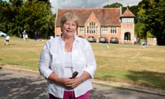 Headteacher in front of green and village school