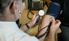 A GP checks a patient's blood pressure