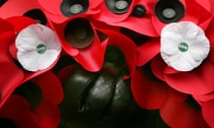 Service-goer holds red poppy wreath decorated with white poppies of peace during service at Cenotaph in central London<br>A service-goer holds a red poppy wreath decorated with white poppies of peace during a service to remember those military personnel and civilians killed in the recent conflicts in Iraq and Afghanistan at the Cenotaph in central London, on Armistice Day, November 11, 2006. Millions of people across Britain observed a two-minute silence to remember the nation's war dead on Saturday. REUTERS/Toby Melville (BRITAIN) - GM1DTXOWVZAA