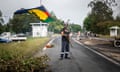 A resident at a roadblock waves a Kanak flag in New Caledonia.