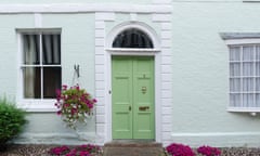 Front door to a house with a hanging basket containing flowers