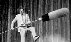 Ken Dodd holding an enormous tickling stick on the stage of the London Palladium 1990.
