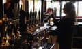 A bartender pulls a pint in a pub