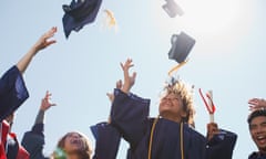 Black, female university graduates throw mortar-board hats in the air