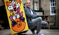 Masai Graham  poses next to a cartoon of a clown in Edinburgh.