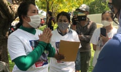 Cambodia's 'Friday Wives' leader Prum Chantha (with hands clasped together) speaks with a representative from the Australian Embassy in Phnom Penh.