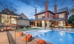 A luxury property in Armadale, Melbourne, showing a luxurious pool against a red-brick home with three chimmneys