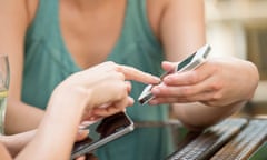 Friends pairing smartphones to exchange data.