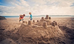 Two little boys building sandcastle on beach<br>Two little boys building big sandcastle on beach while on holiday.