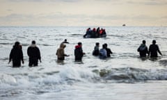 Migrants wade to a smuggler’s boat at Dunkirk in April. 