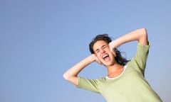 Woman covering ears and screaming outdoors.<br>AM9MAR Woman covering ears and screaming outdoors.