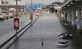 A person stands surrounded by flood water caused by heavy rains, in Dubai, United Arab Emirates, on Wednesday.