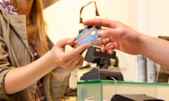 Woman handing over a card at retail checkout