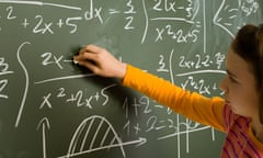 An 11-year-old girl with a serious expression, wearing a long-sleeved, striped orange top, chalks complex-looking algebraic equations on a blackboard