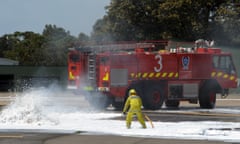 Firefighters douse flames from a burning plane during a training exercise at Sydney International airport