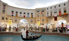 Motor-powered gondolas for hire on the fake canal with a fake sky painted on the roof inside the Villagio Mall which is decked out with World Cup flags