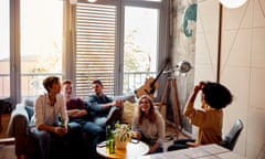 Photo of friends sitting in the living room, having fun and playing charades together