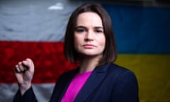 A determined-looking woman in a suit gives a clenched-fist salute