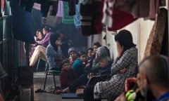 Internally displaced Palestinians sit in a corridor at a UN school in Deir al-Balah, southern Gaza, on 24 February.