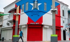 A man walks through a closed commercial area in San Juan, Puerto Rico