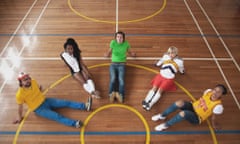 the go team members seen from above and sitting in a semicircle on a baskteball court