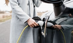 A woman charges her electric vehicle. Electric carmarking operations of companies like Toyota, Volkswagen and BMW are likely to become more profitable than traditional arms of the company, modelling suggests.