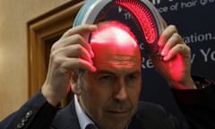 BBC television reporter Rory Cellan-Jones tries out a HairMax Laserband, a hands-free device described to treat hair loss and cause new hair growth, during the opening event at the Consumer Electronics Show in Las Vegas January 4, 2016. REUTERS/Rick Wilking - RTX211KB