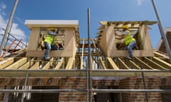 Carpenters working on the roof of a new house.