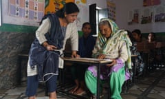 A teacher helps Amma, 92, in the classroom in Bulandshahr, Uttar Pradesh.