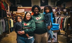 A family of four smiles at the camera inside an outdoor gear shop.