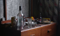 Very dirty bedside table with beer bottles, tins, vodka bottle and cigarette butts<br>BRHPRR Very dirty bedside table with beer bottles, tins, vodka bottle and cigarette butts